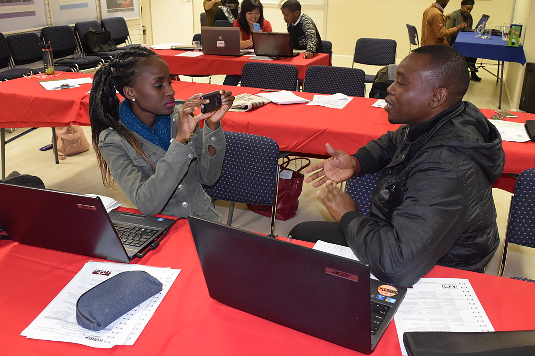 Woman filming a young man giving a presentation